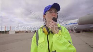 女职工机场在飞机的背景下广播讲话
